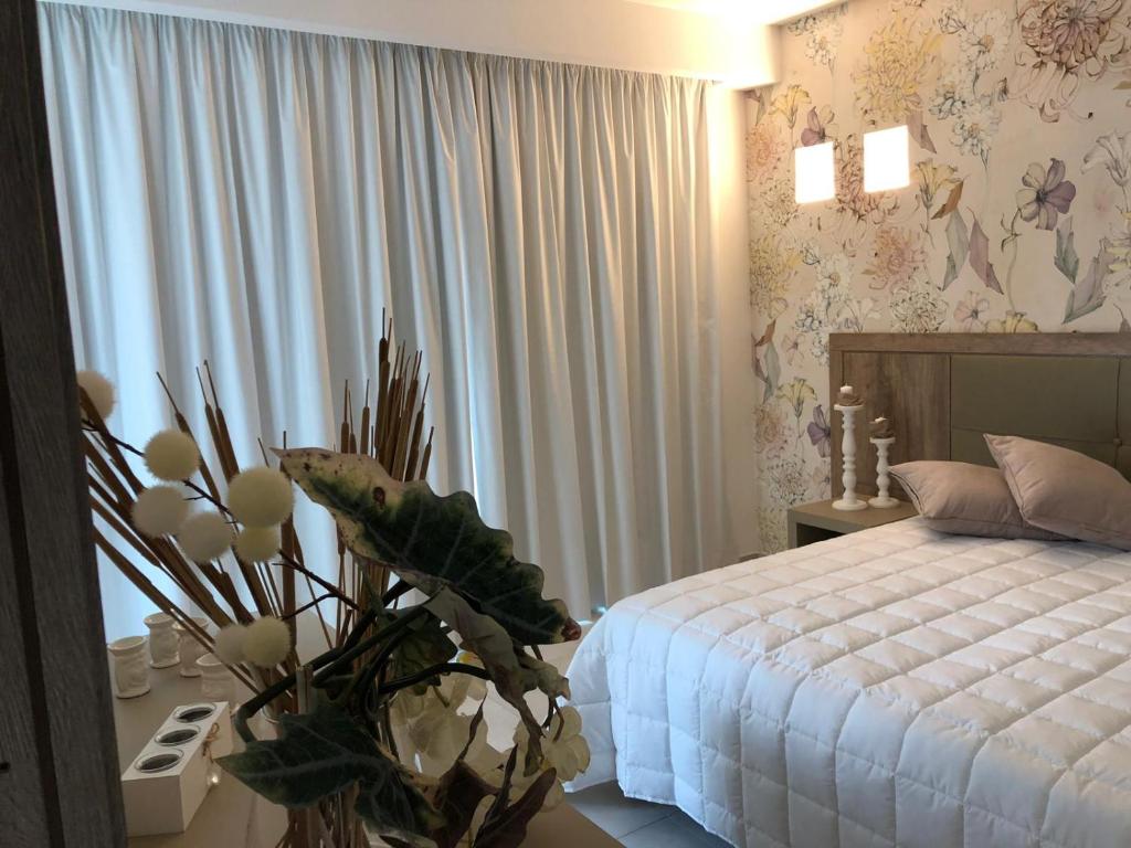 パレルモにあるHotel Pontemareのベッドルーム1室(ベッド1台、植物のあるテーブル付)