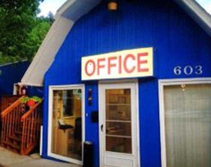 a blue building with an office sign on it at The Brookside Motel / Mt. Rushmore in Keystone