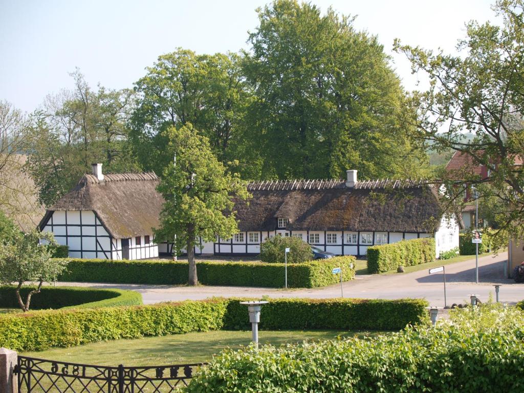 a building with a roof with trees and a park at Baekgaarden B&B in Sandholts-Lyndelse