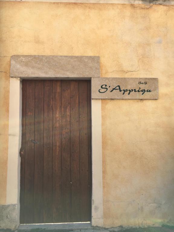 a wooden door on the side of a building at S'Apprigu B&B in Càbras