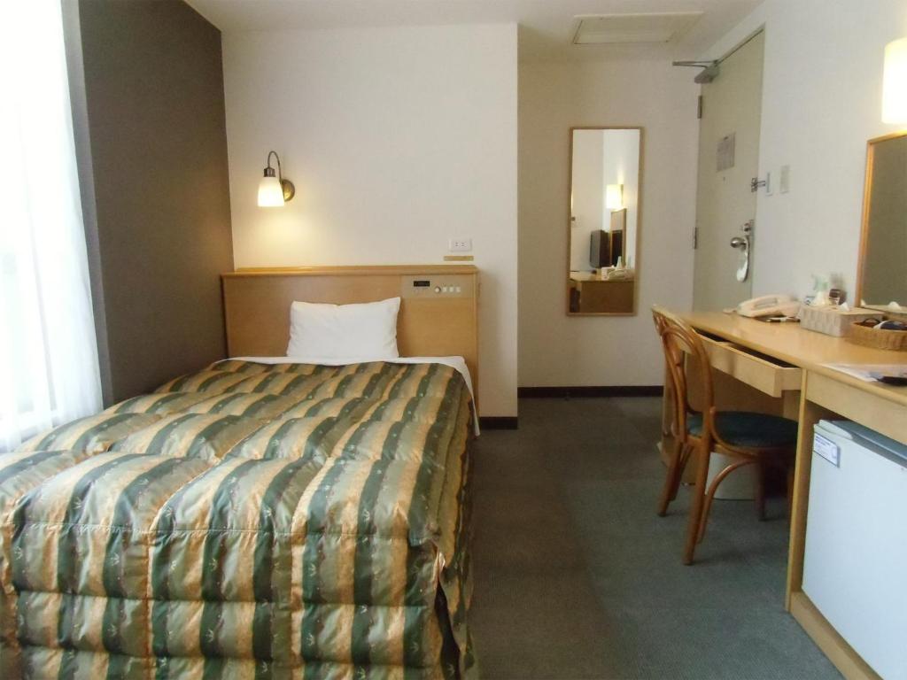 a hotel room with a bed and a desk at Hotel Oaks Early-Bird Osaka Morinomiya/ Vacation STAY 28682 in Osaka