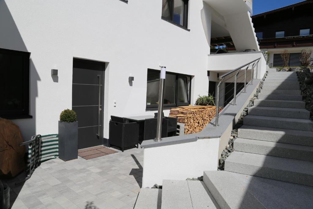 a white house with stairs and a balcony at Appartement Ilvy in Söll