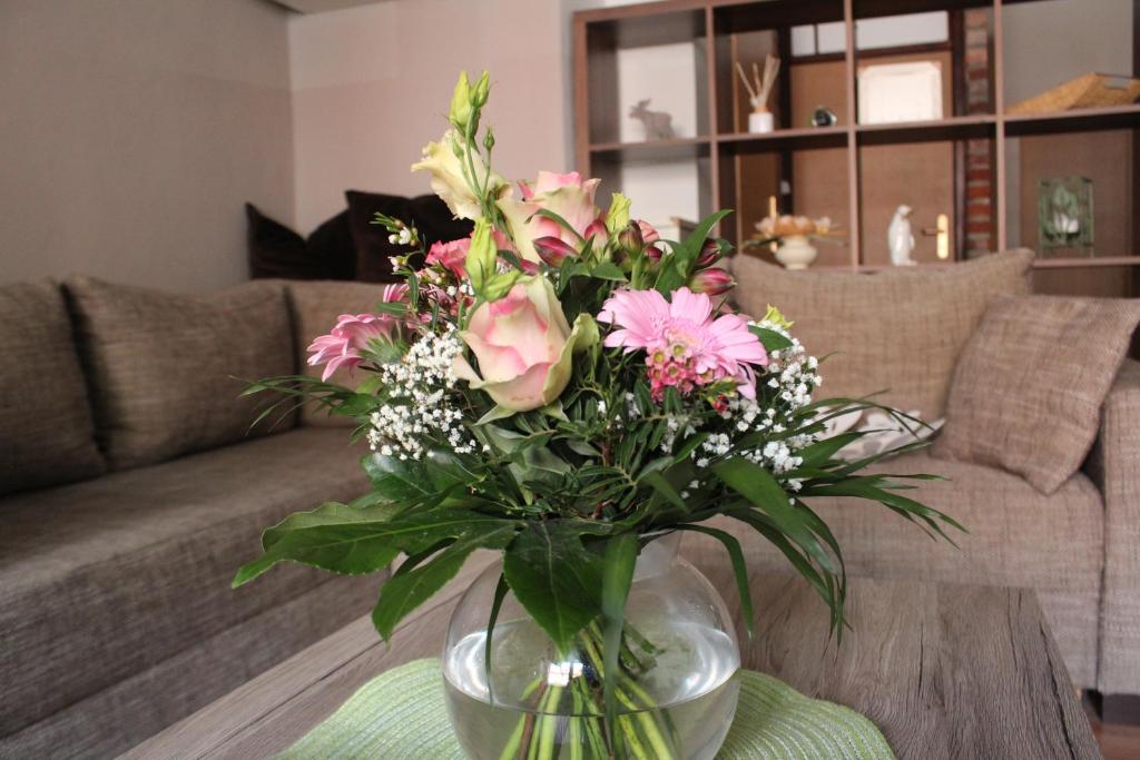a vase filled with pink flowers on a table at Gästewohnung Müntzer in Lutherstadt Wittenberg