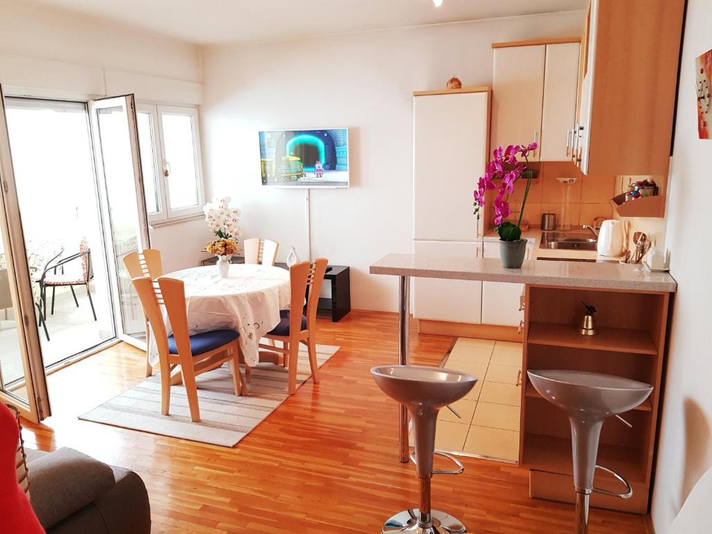 - une cuisine et une salle à manger avec une table, une table et des chaises dans l'établissement Apartment Ante, à Split