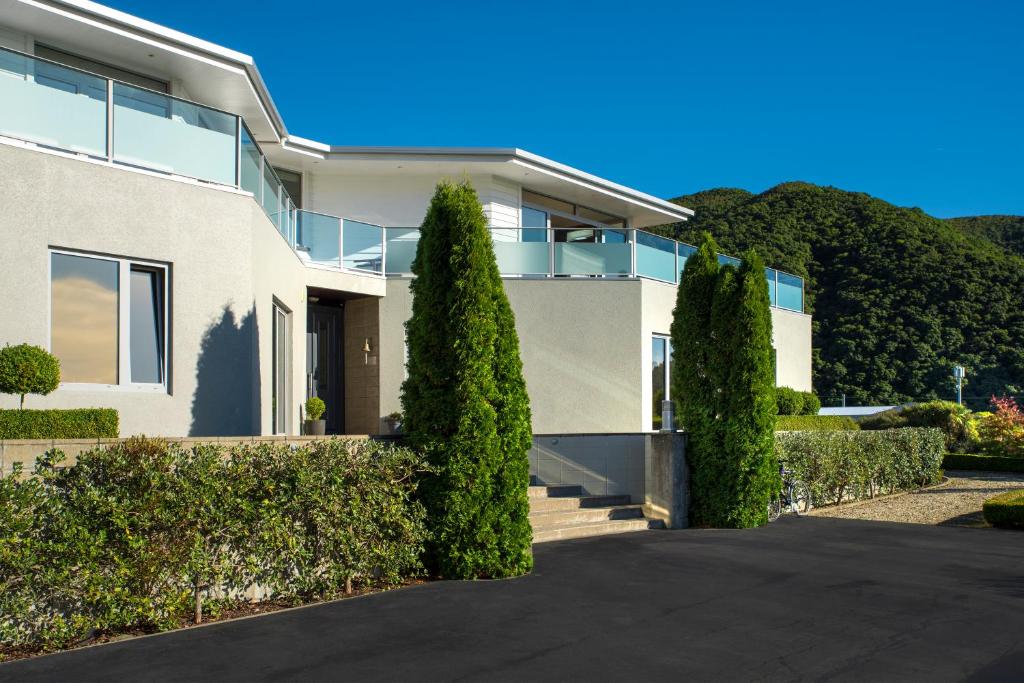 a white house with trees in front of it at Wilkes Way Villa in Picton