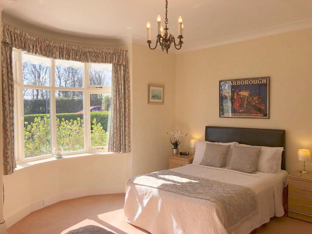 a bedroom with a bed and a large window at White Gable in Scarborough