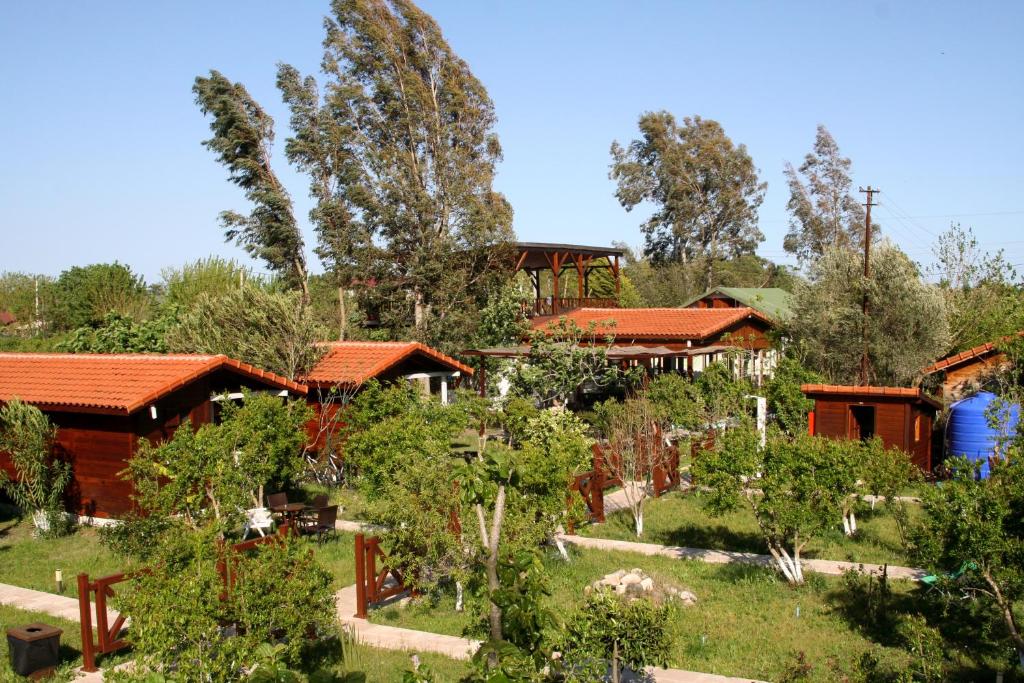 un jardín frente a una casa con árboles en La Boutique Hemerans Çıralı, en Cıralı