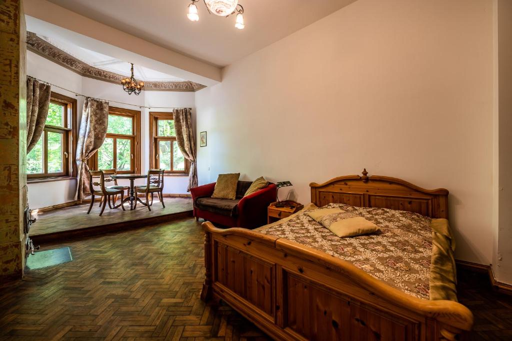 a bedroom with a wooden bed and a living room at Villa Apartments by the sea in Liepāja