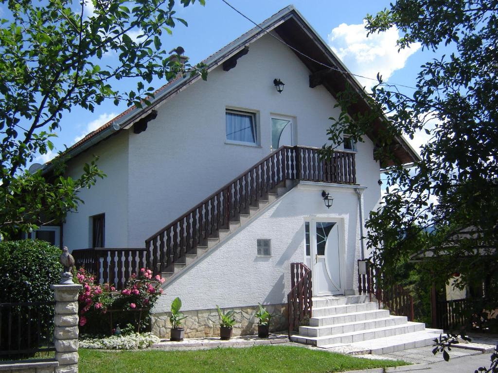 ein weißes Haus mit Treppen, die zu ihm führen in der Unterkunft Apartments Sanja in Rakovica