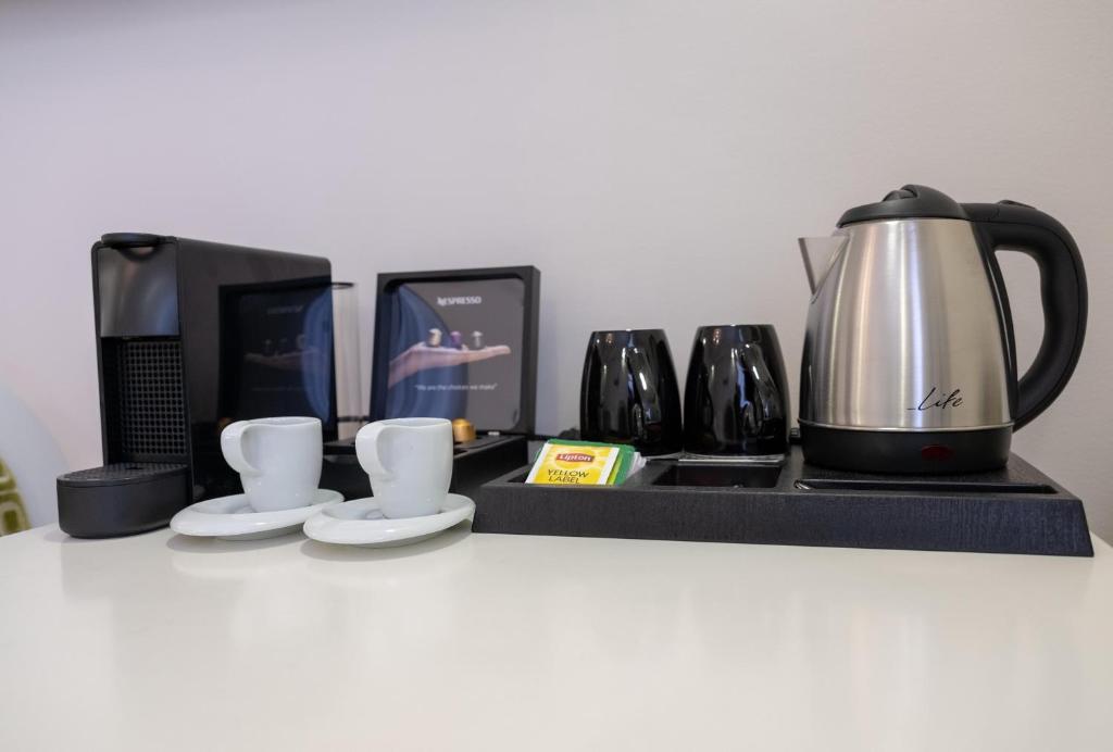 a counter with a coffee maker and a tea kettle at Eva Mare Hotel & Suites - Adults only in Agia Pelagia