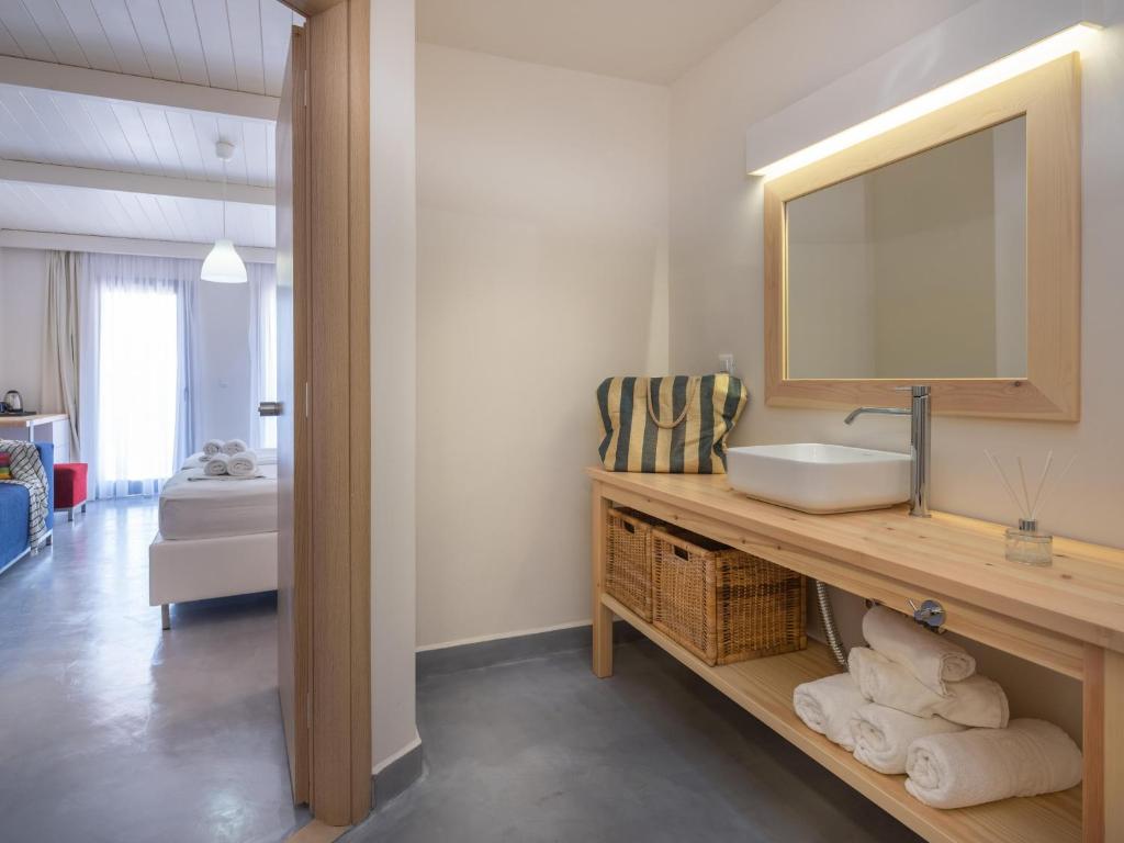 a bathroom with a sink and a mirror at Eva Mare Hotel & Suites - Adults only in Agia Pelagia