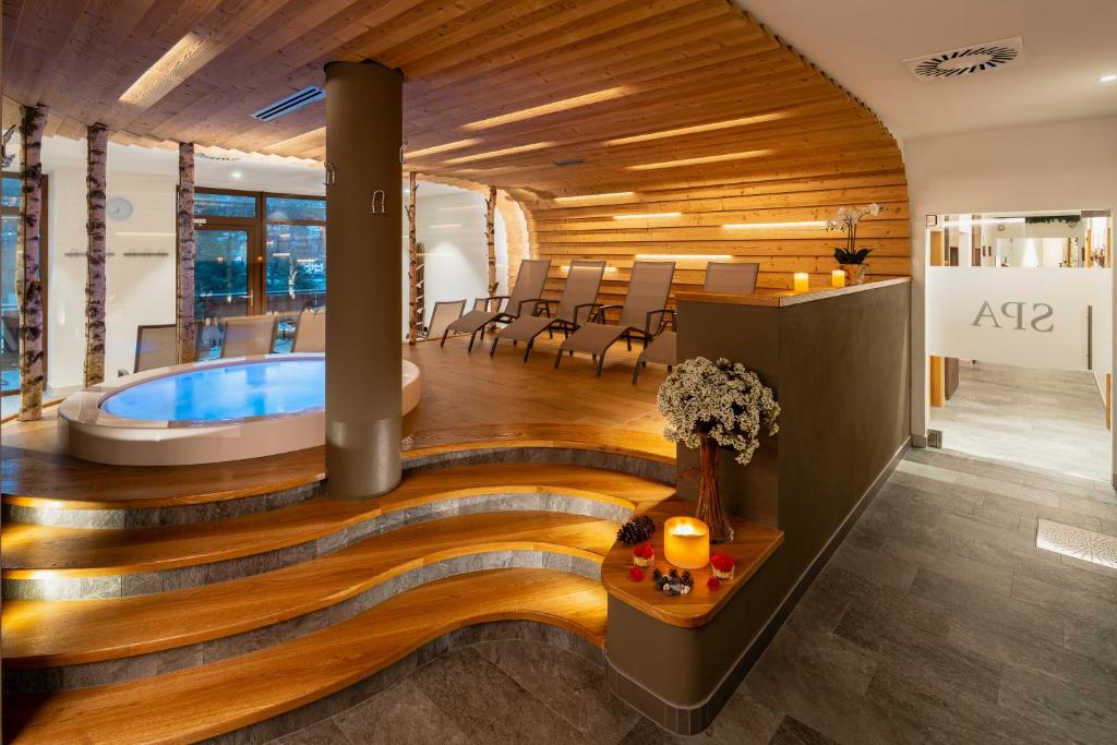 una sala benessere con vasca idromassaggio e sala da pranzo di Hotel Columbia & Spa a Cortina dʼAmpezzo