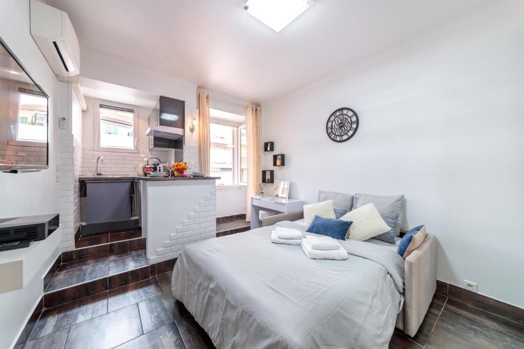 ein weißes Schlafzimmer mit einem Bett und einer Küche in der Unterkunft Beau studio à 50m de la plage in Nizza