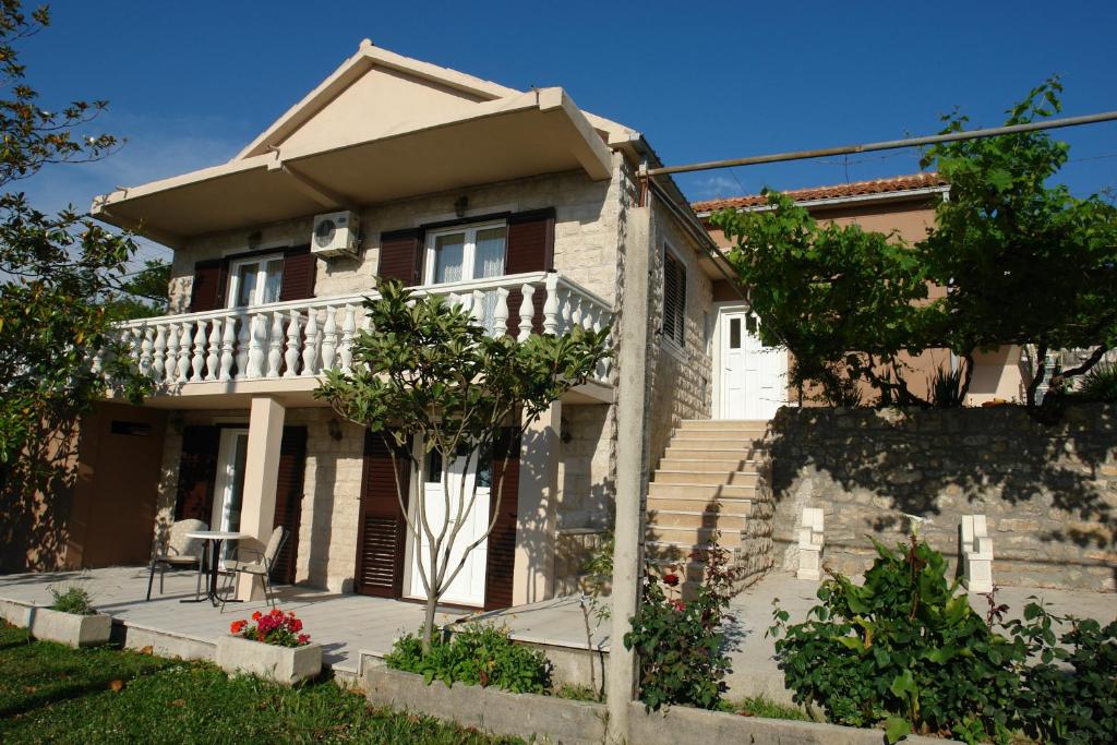 a house with a balcony and a table on a porch at R&B Apartments in Budva