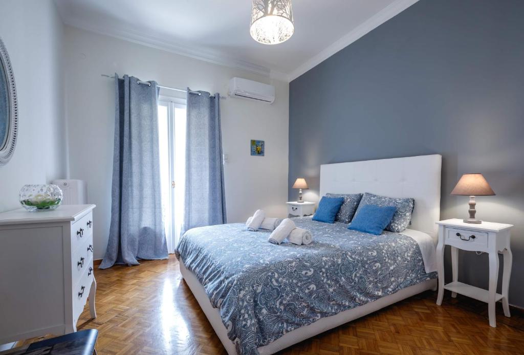 een slaapkamer met een groot bed met blauwe kussens bij Androniki Apartment in Nafplio