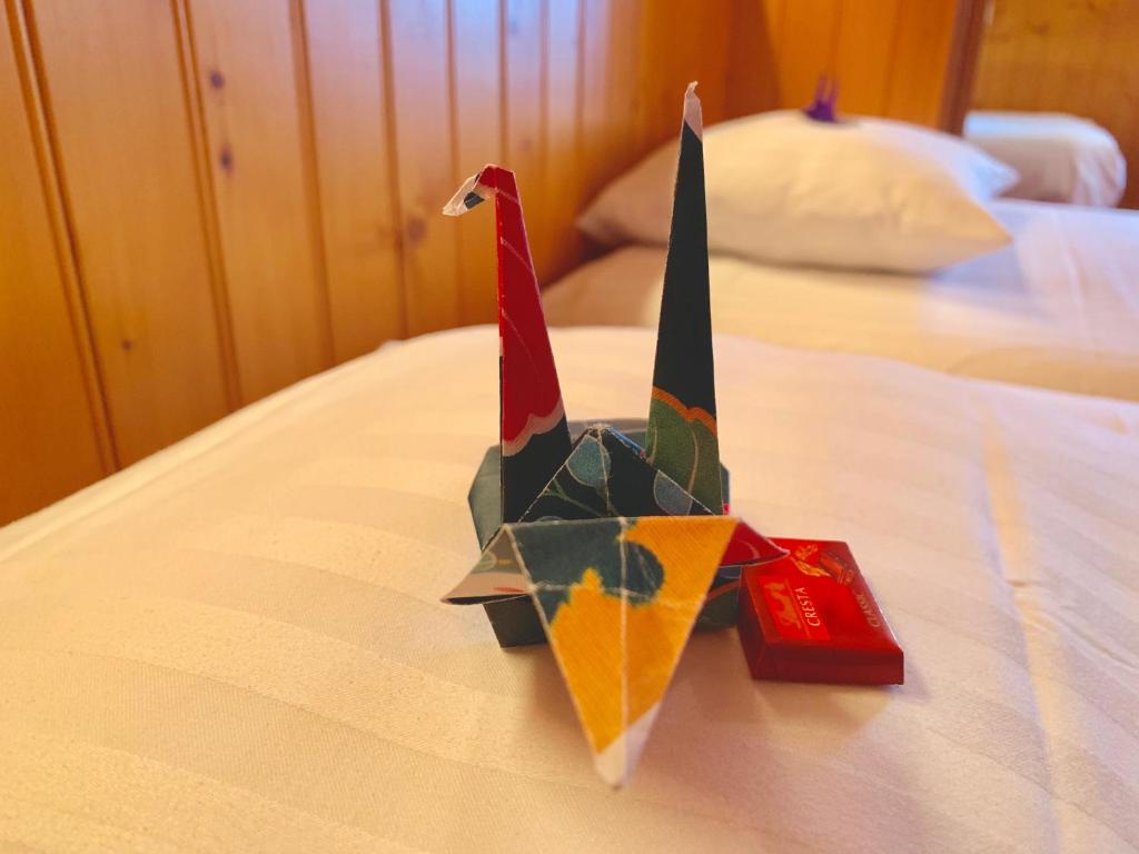 a origami bird sitting on top of a bed at Hôtel Ecureuil Villars in Villars-sur-Ollon