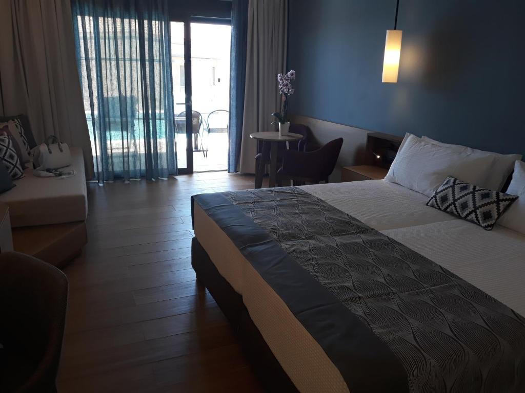 A bed or beds in a room at Apollonion Asterias Resort and Spa