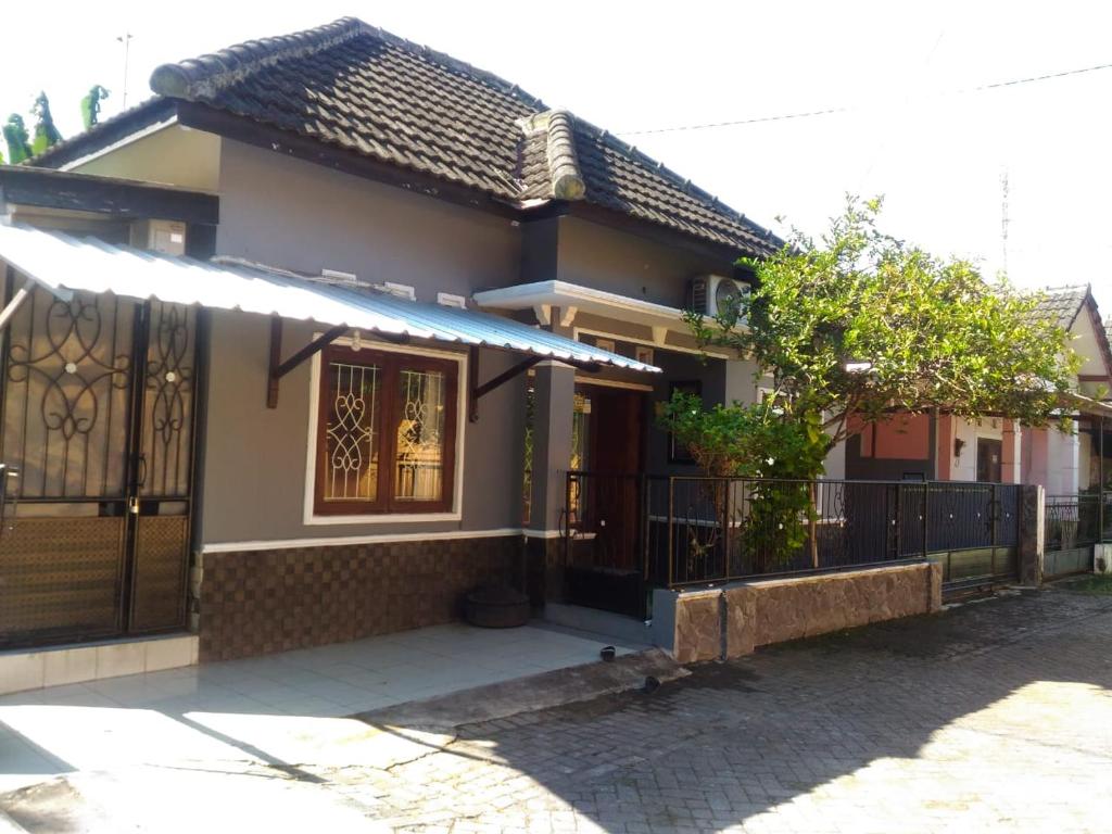 ein kleines Haus mit einem Tor und einem Zaun in der Unterkunft Herry Home Stay_Jogja in Yogyakarta