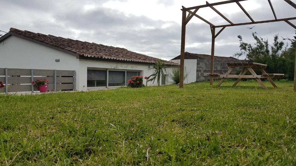 a picnic table in a yard next to a house at Our relaxing holiday home in Mosteiros
