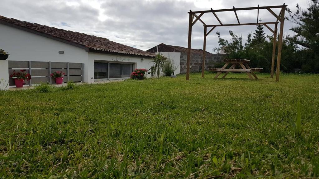 a picnic table in a yard next to a house at Our relaxing holiday home in Mosteiros