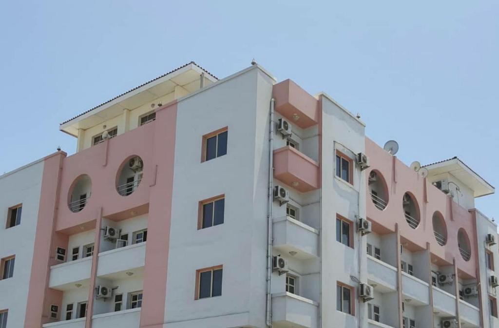 un immeuble d'appartements rose dans l'établissement Comfort Hotel, à Djibouti