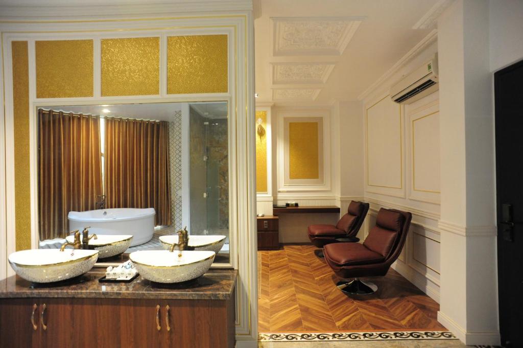 B.O.B Hotel في Cao Lãnh: حمام به مغسلتين وحوض استحمام