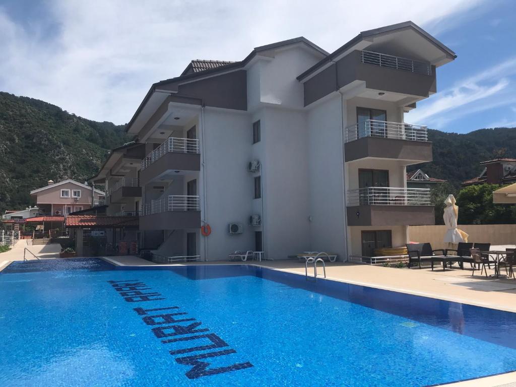 a villa with a swimming pool in front of a building at Murat Apart Hotel in Marmaris