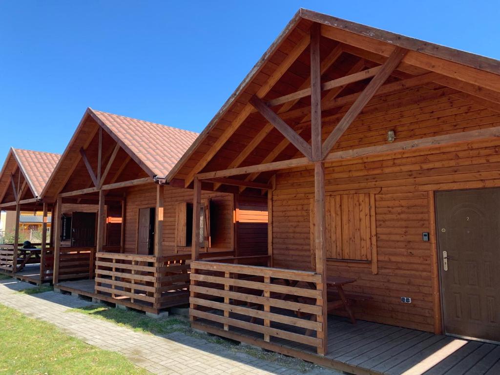 Cabaña de madera con porche y puerta en Domki Międzyzdroje en Międzyzdroje