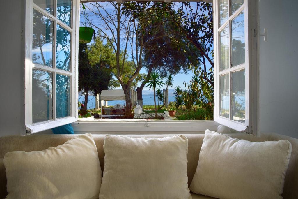 un sofá sentado frente a una gran ventana en Villa Spiaggia Bianca en Dafnila