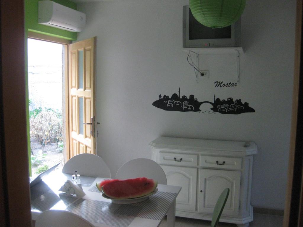 a kitchen with a table with a bowl of watermelon on it at Hostel Bojo in Mostar