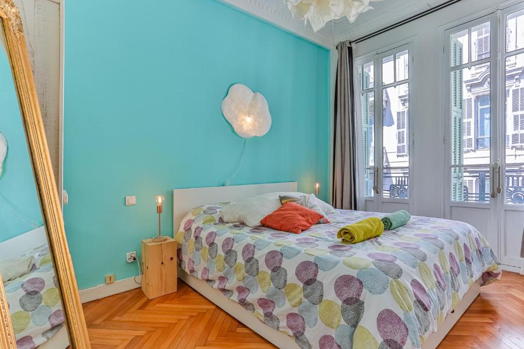 - une chambre avec des murs bleus et un lit avec un miroir dans l'établissement Maison Bianchi - 29 Tonduti, à Nice