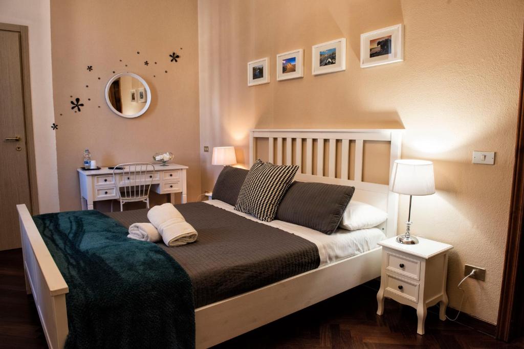 a bedroom with a bed, desk and a lamp at Corso 151 in Olbia