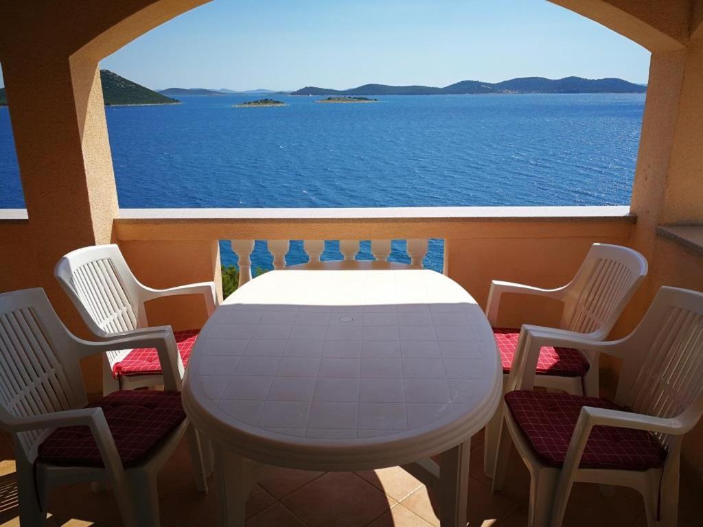 Biały stół i krzesła z widokiem na ocean w obiekcie Apartments Buki-sea view w mieście Drage
