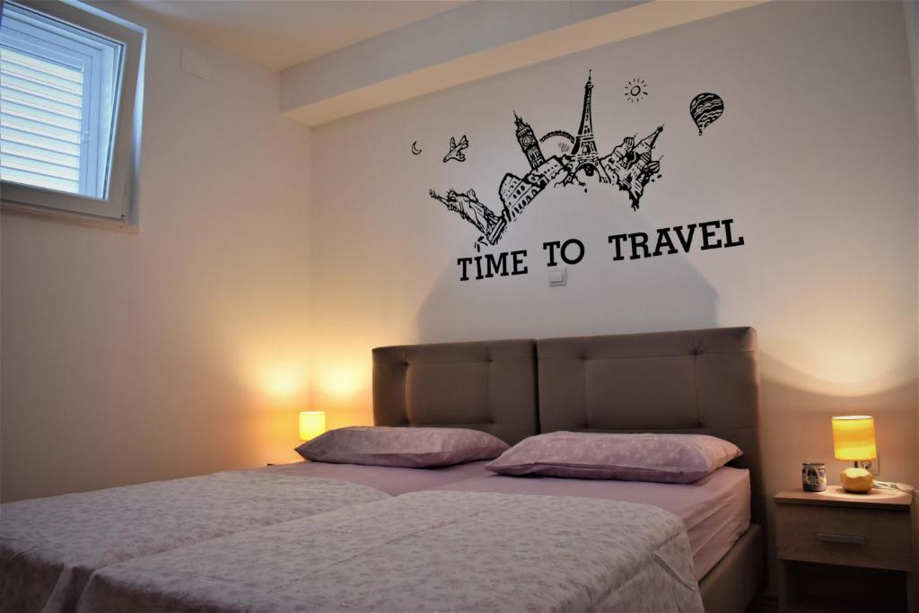 - une chambre avec un lit avec les mots temps pour voyager dans l'établissement Apartman Anamarija, à Split