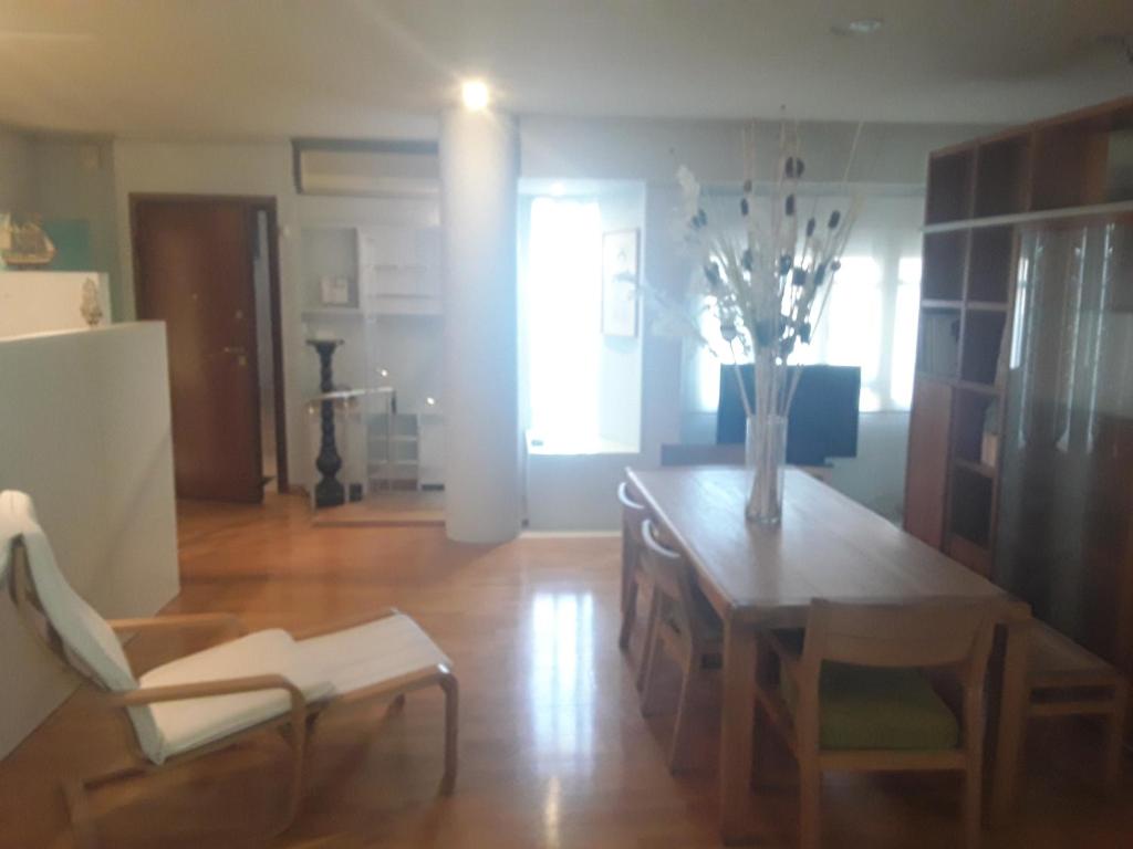 una sala de estar con una mesa y un jarrón de flores en Deluxe Apartment Best Point en Athens