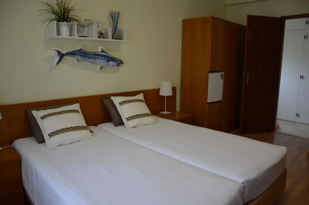 a bedroom with a bed with a fish on the wall at ABLA Guest House in Carcavelos