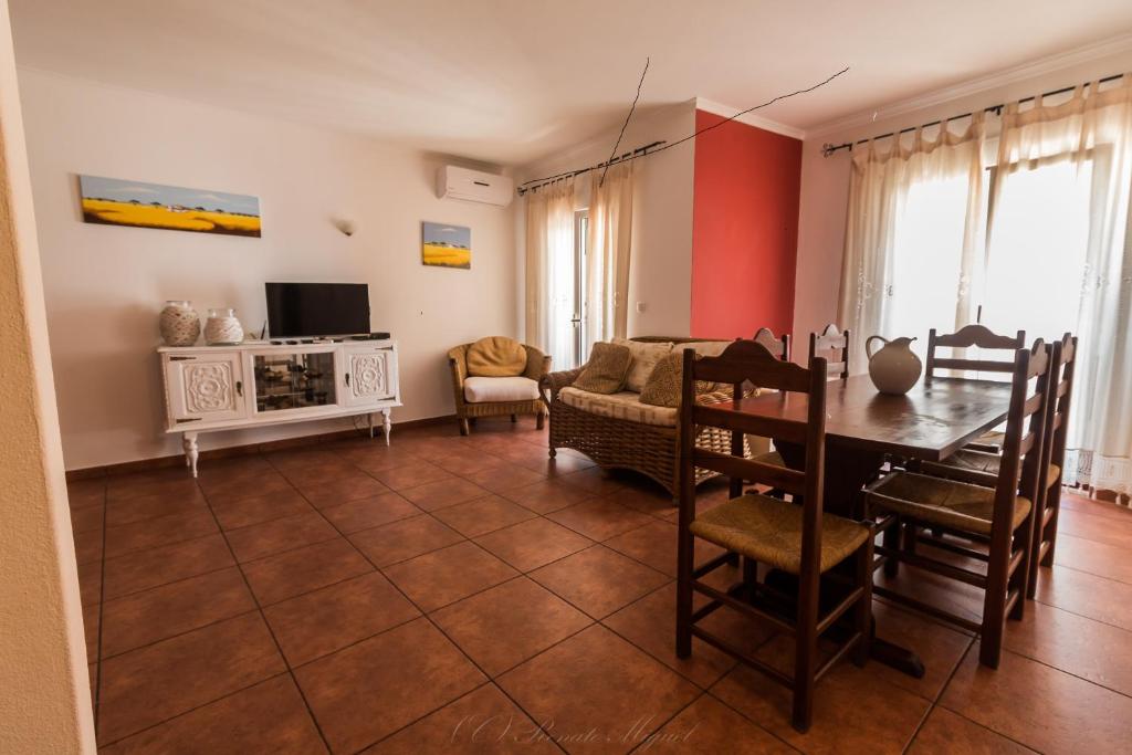 a living room with a table and a dining room at APARTAMENTO TELHEIRO in Vila Nova de Milfontes