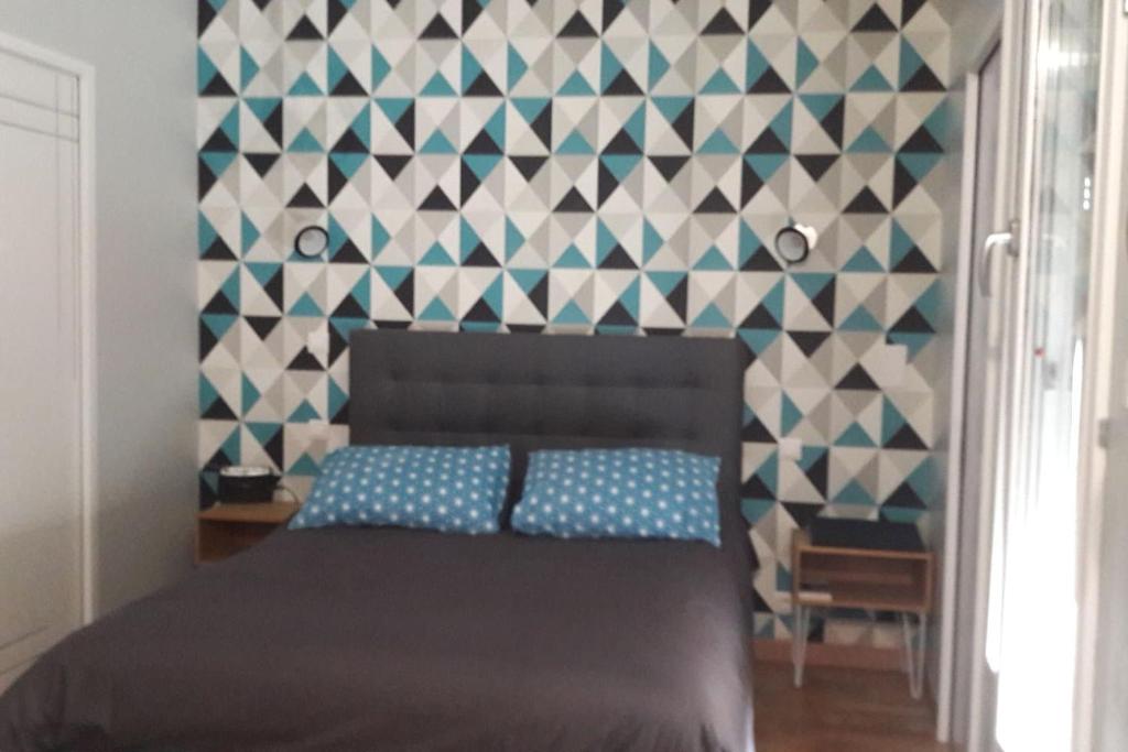 Un appartement lumineux au parc beaumont في بو: غرفة نوم بسرير بجدار ازرق وابيض