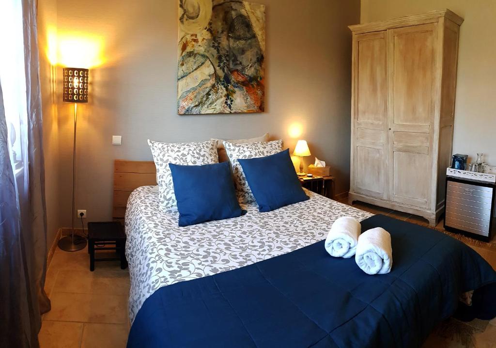 een slaapkamer met een groot bed met blauwe kussens bij La Villa Esterel & SPA in Village-Neuf