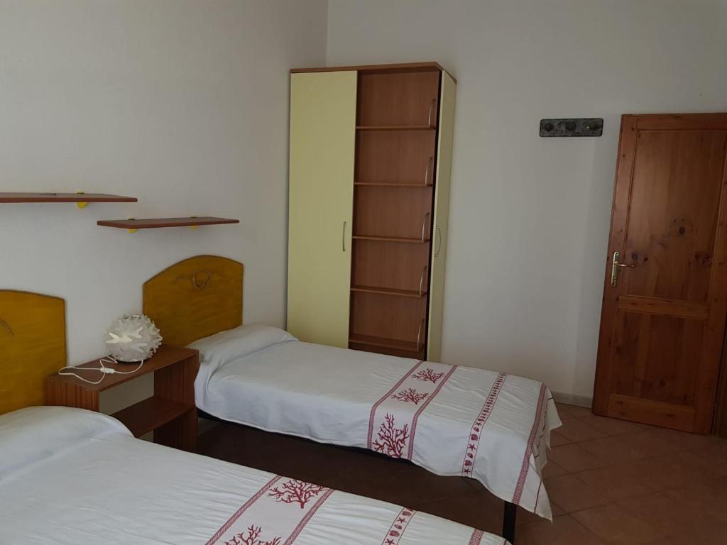 una habitación de hotel con 2 camas y una puerta en Casa Ermanno en Posada
