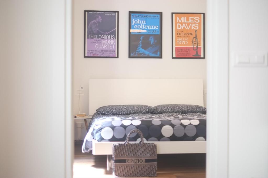 una camera da letto con un letto con quattro poster appesi al muro di Casa Miranda a La Spezia