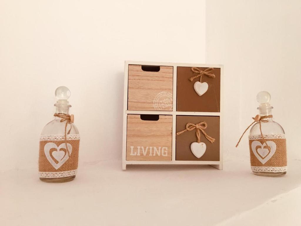 two bottles with hearts on them sitting next to a box at Casa Kito in Constanţa