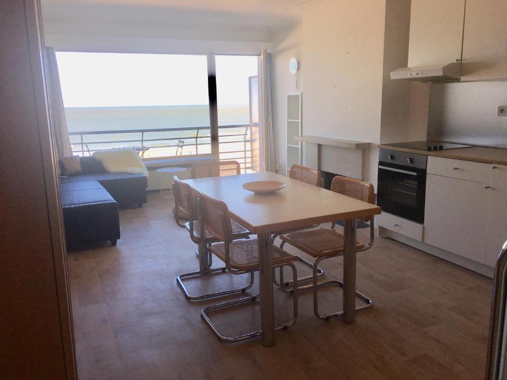 a kitchen and living room with a table and chairs at Superbe Appart vue mer avec balcon in Blankenberge