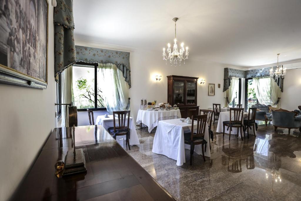 a dining room with tables and chairs and a chandelier at Villa Borghese B&B in Foggia