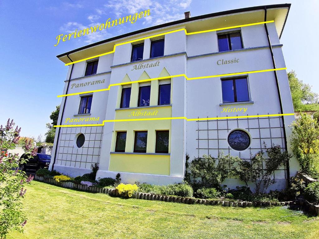 a white building with yellow stripes on it at Ferienwohnung Albstadt Panorama in Albstadt