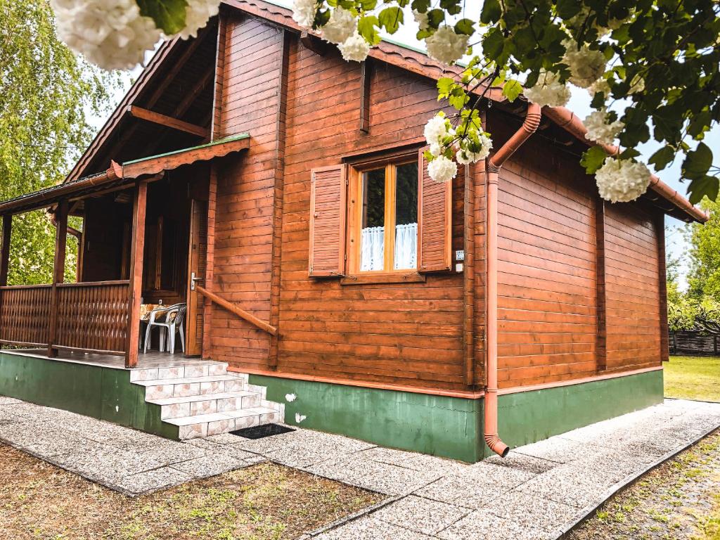 een blokhut met een veranda en een raam bij Lake House Farsang in Balatonberény