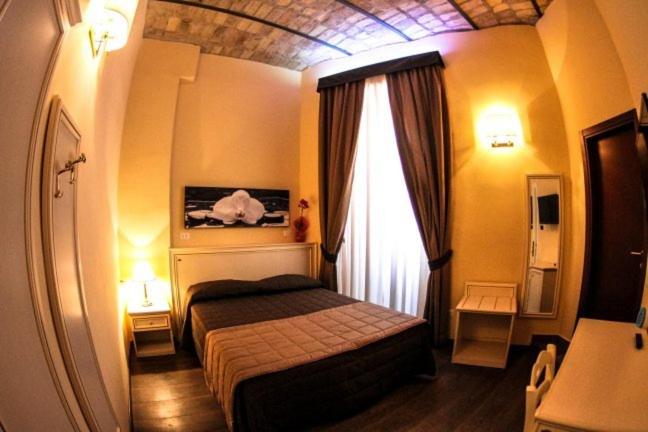a small bedroom with a bed and a window at La Favola di San Pietro in Rome