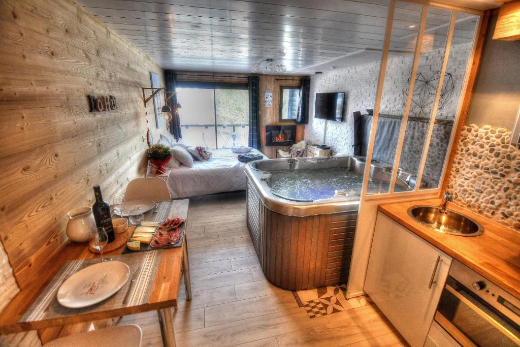 ein Bad mit einer Badewanne und einem Waschbecken in einem Zimmer in der Unterkunft Le Skidoux in Huez