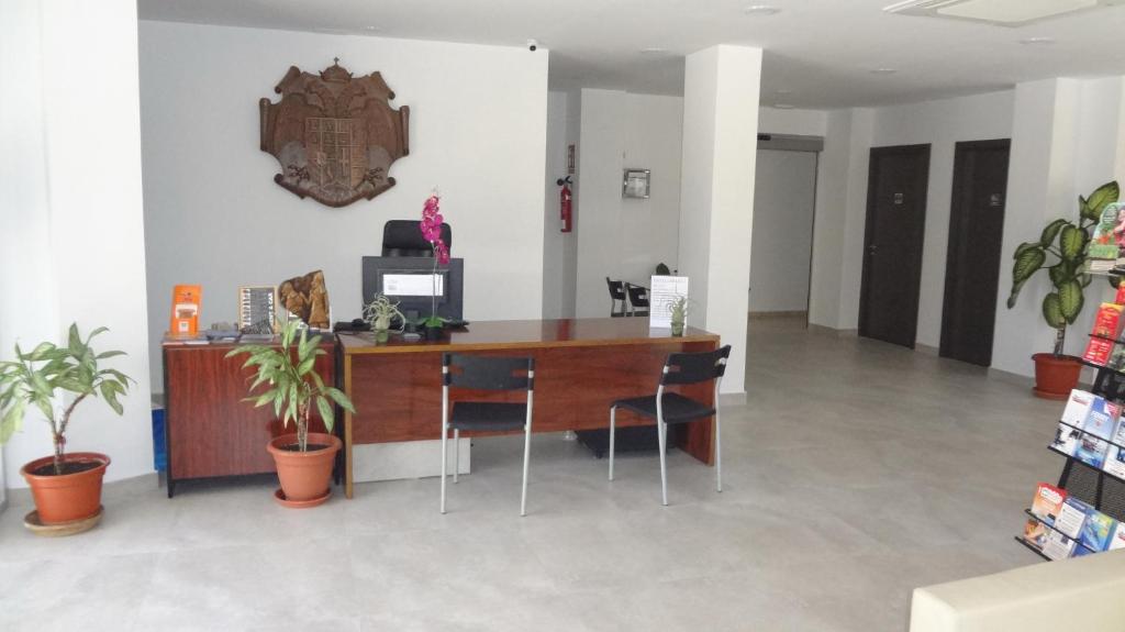 an office with a desk with chairs and a clock on the wall at Hotel Carlos I in Torremolinos