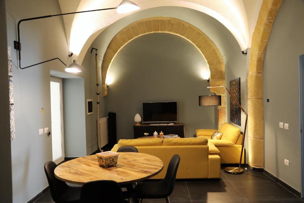 een woonkamer met een tafel en een bank bij Anna & Salvo's House in Marsala